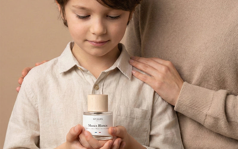 Garçon tenant une bouteille de parfum pour enfant